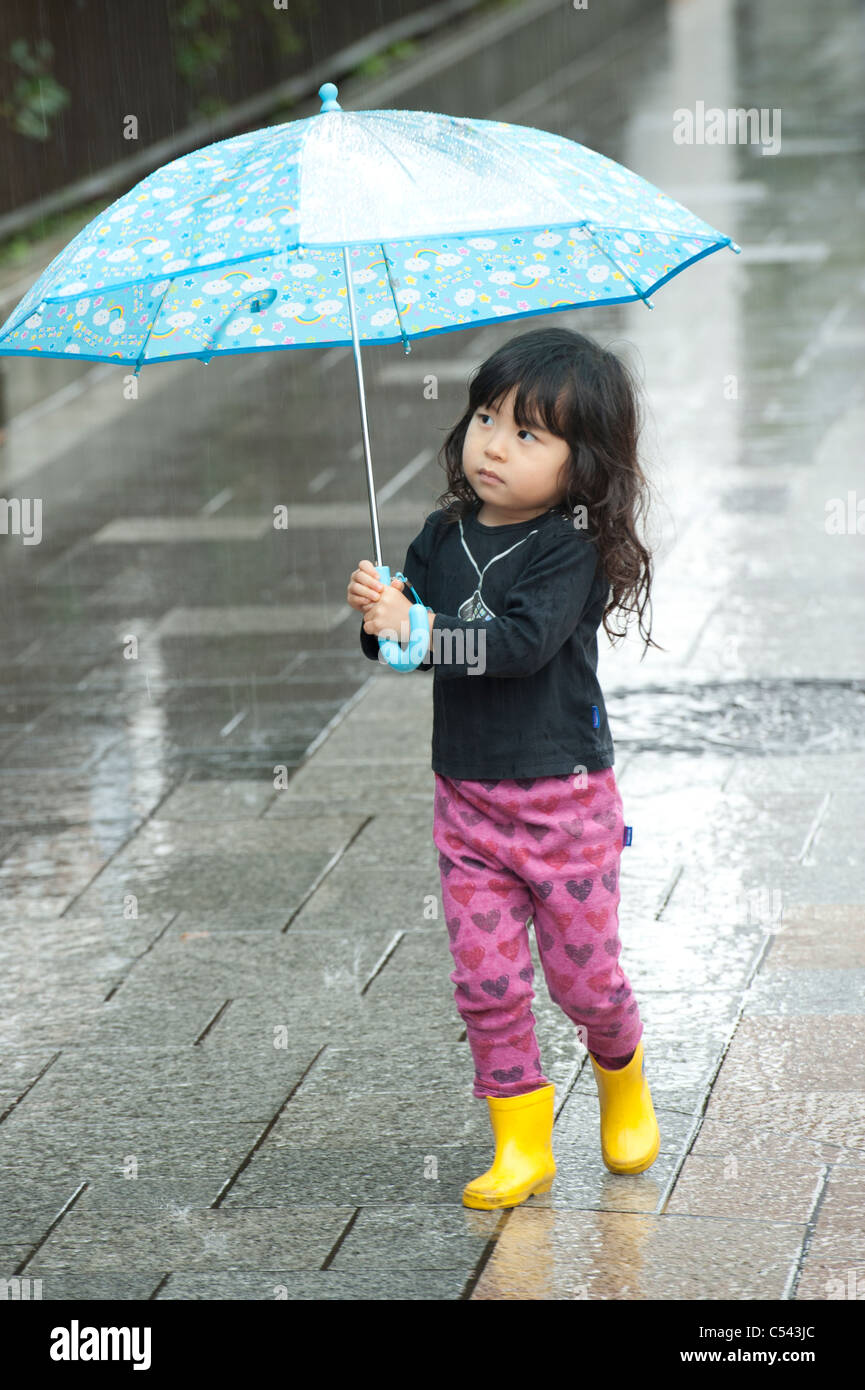 Girl carrying umbrella in rain, Tokyo, Japan Stock Photo Alamy