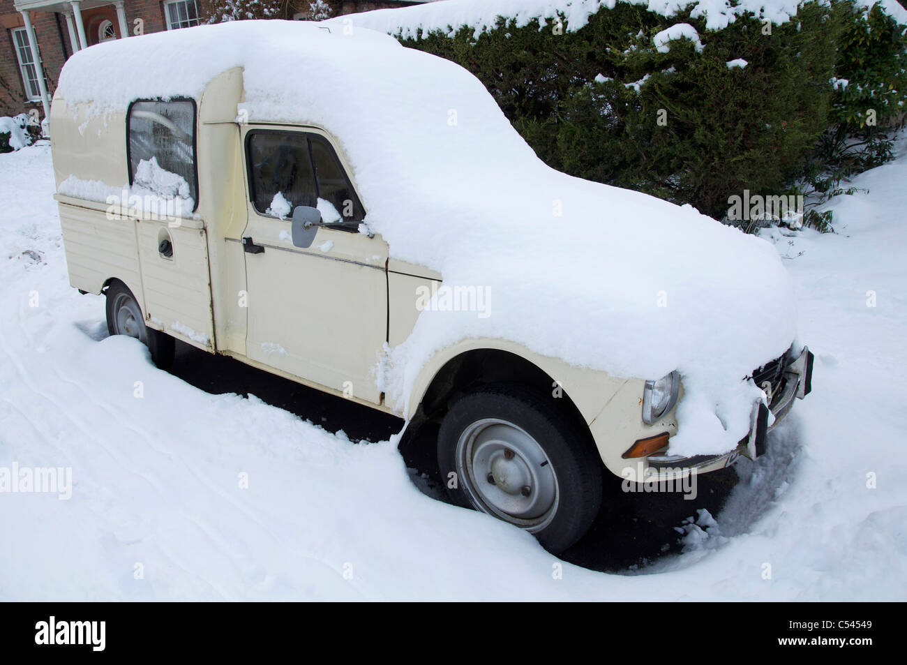 An old classic French Citroën 2CV (deux chevaux) van covered in winter snow, parked in Dorchester, Dorset, England, United Kingdom. Stock Photo