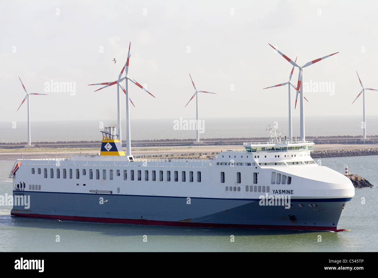 Ferry entering Zeebrugge Harbour, with wind farm in background Stock Photo