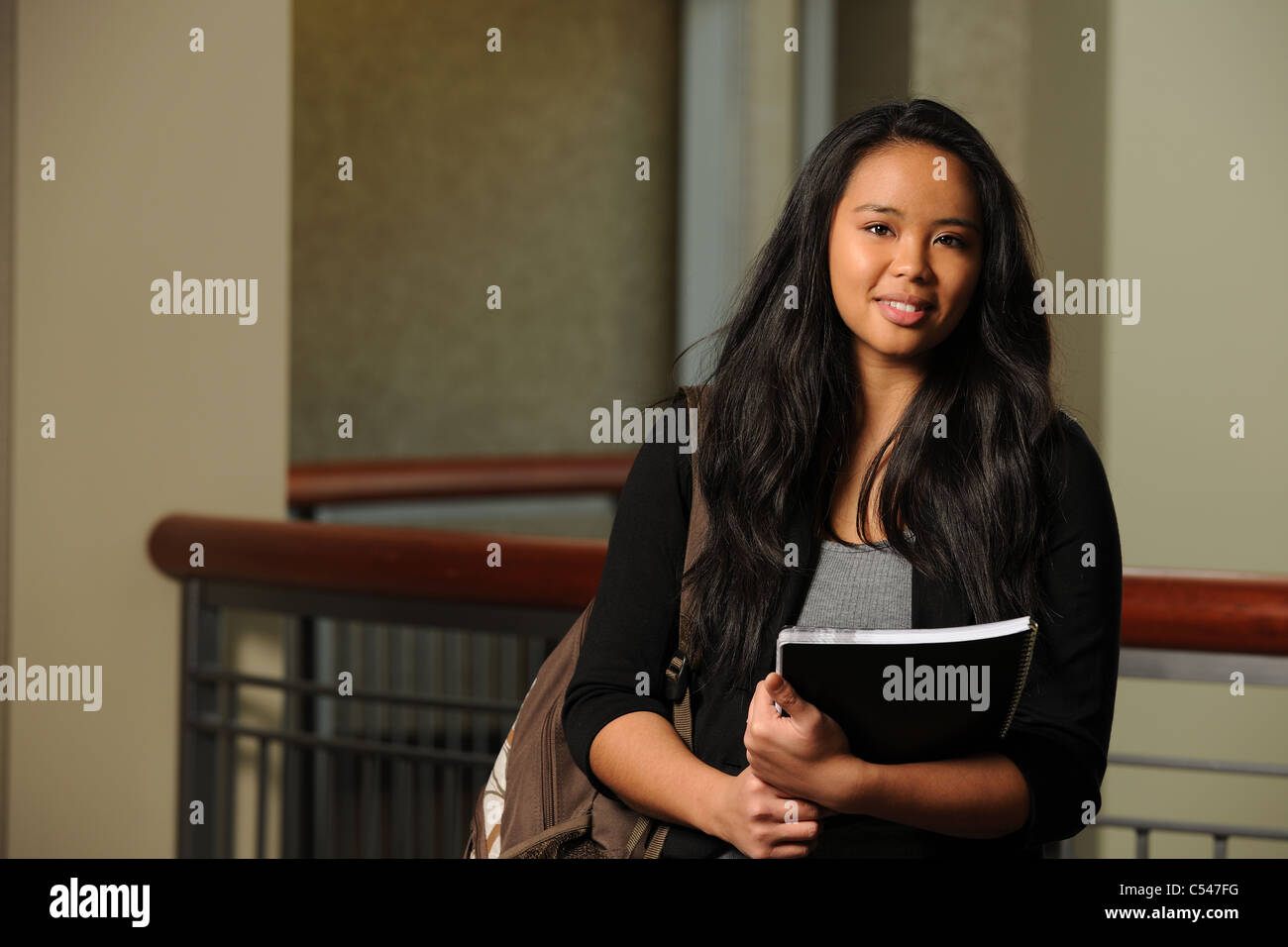 Portrait of Asian female student holding books indoors Stock Photo - Alamy