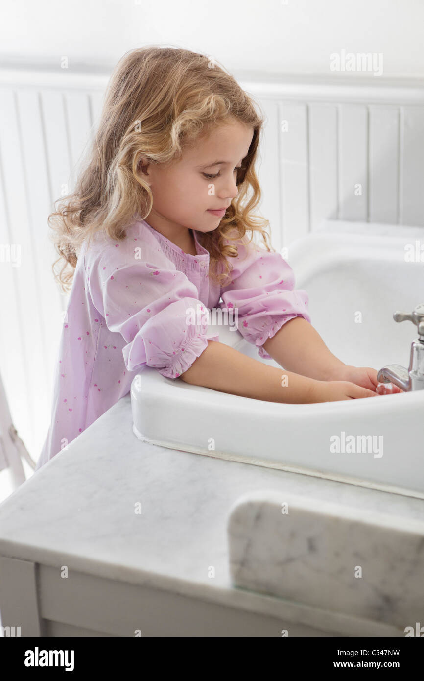 Cute little girl washing hands in bathroom sink Stock Photo - Alamy