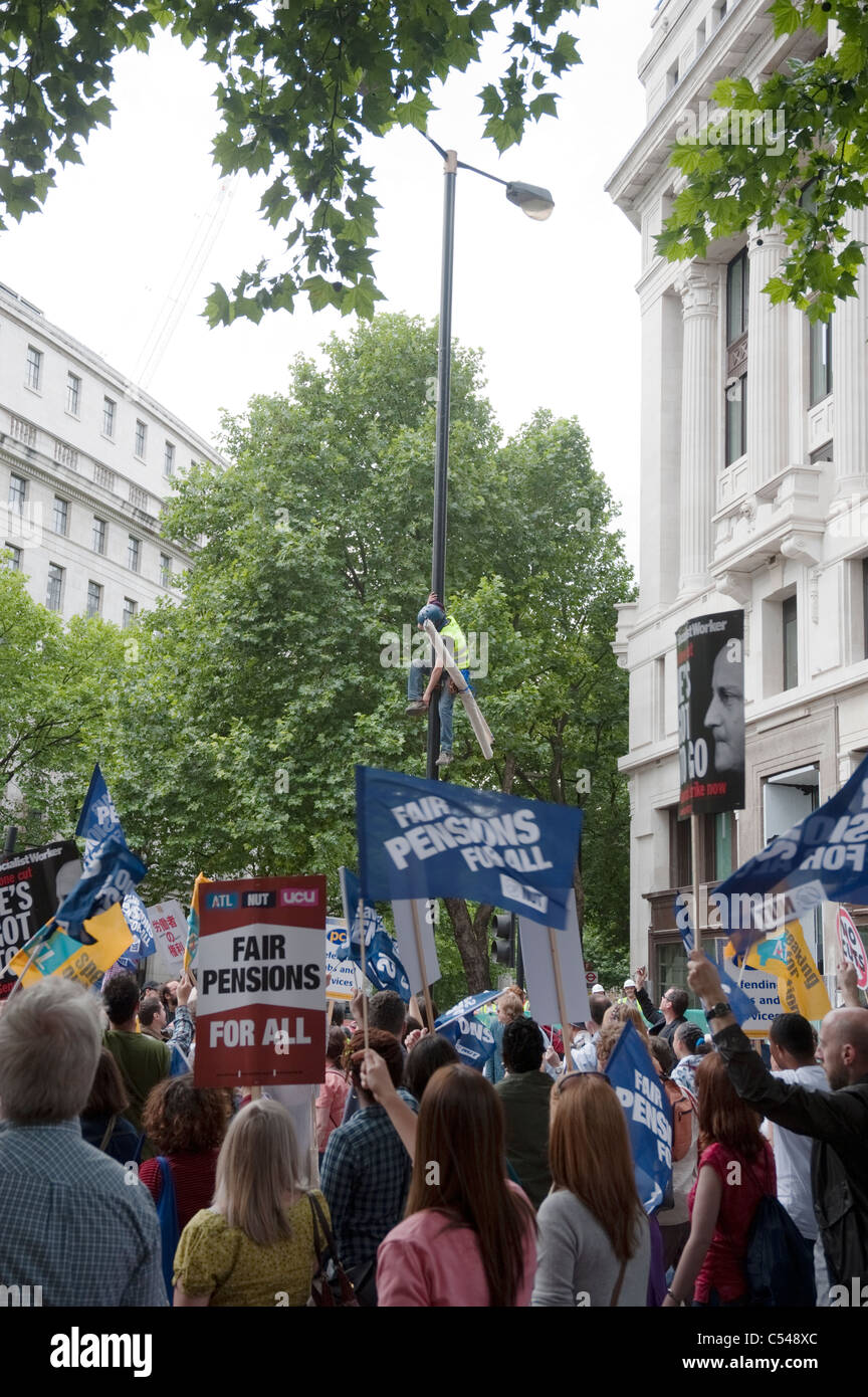Protester climbing lamp post on one day strike by teachers and civil servants to protest at changes in pensions.June 30th 2011. Stock Photo
