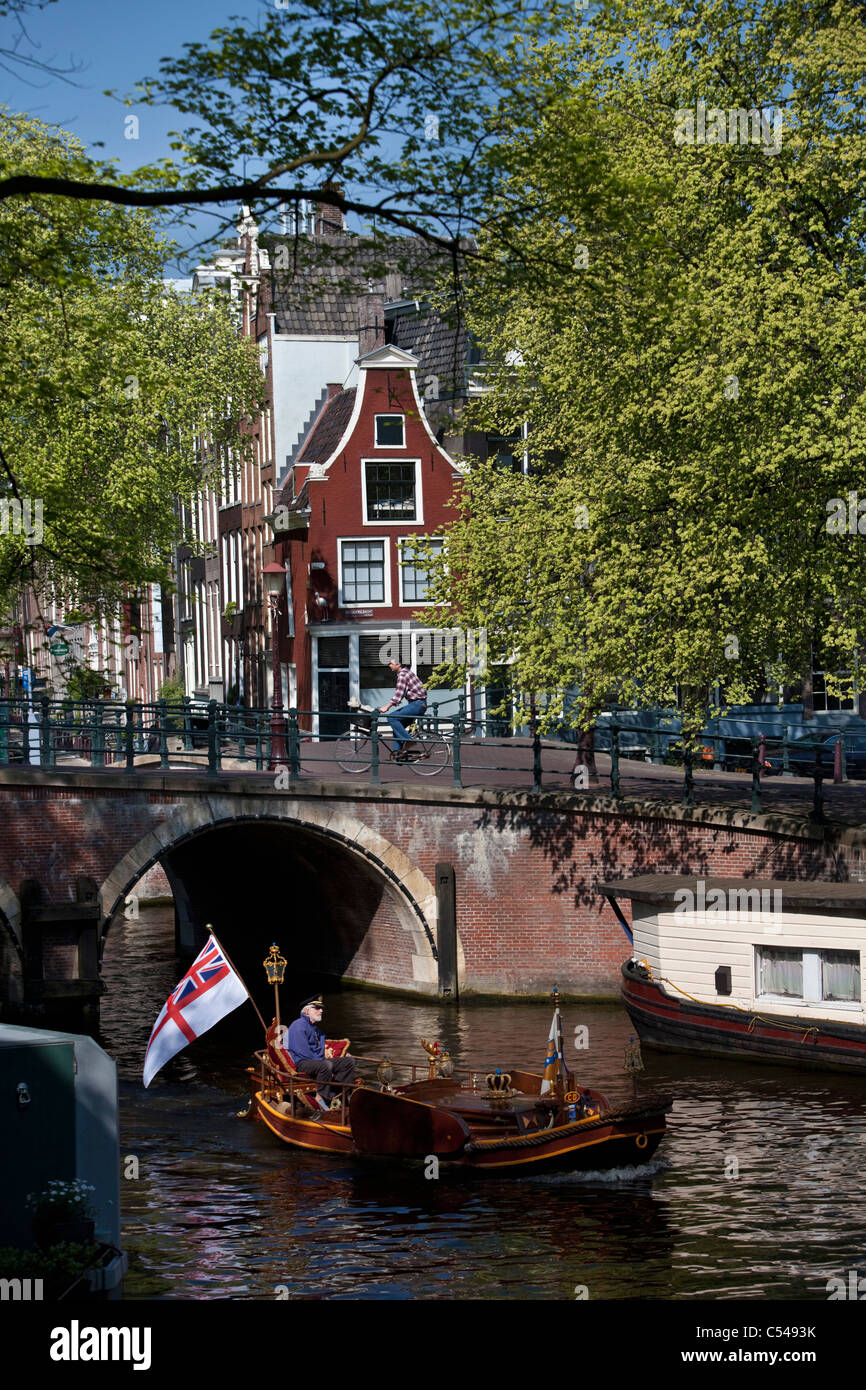 The Netherlands, Amsterdam, Gable house and nicely decorated boat in canal. Unesco World Heritage Site. Stock Photo