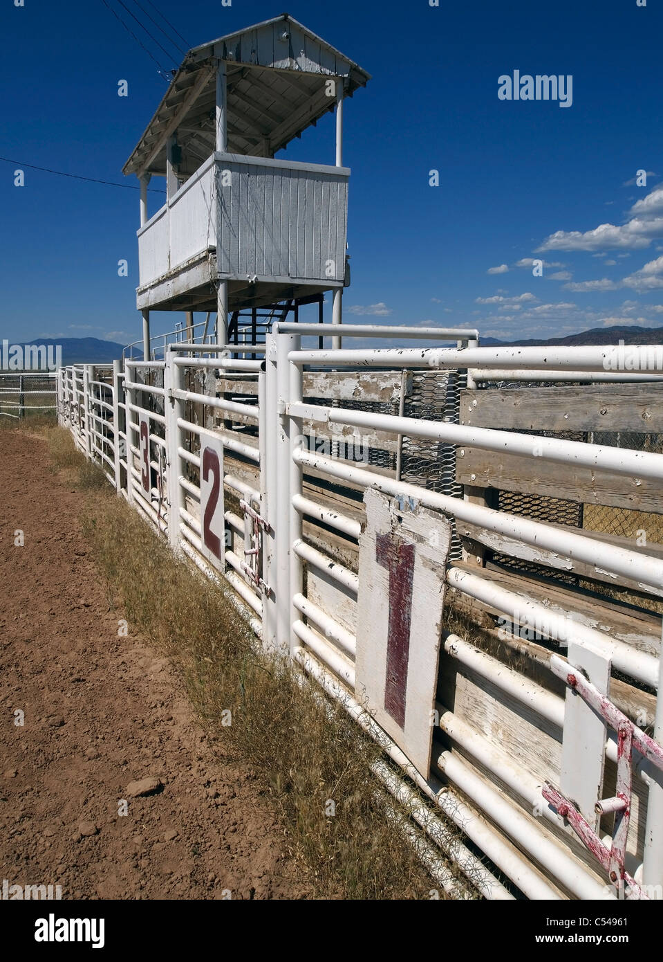 Three rodeo gates beneath the announcer's booth at a rural rodeo Stock