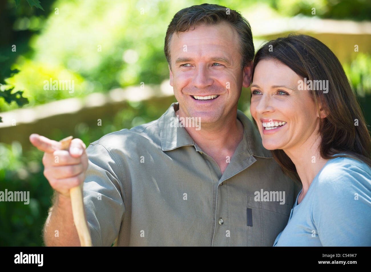 Smiling Man Showing Something To His Wife Outdoors Stock Photo Alamy
