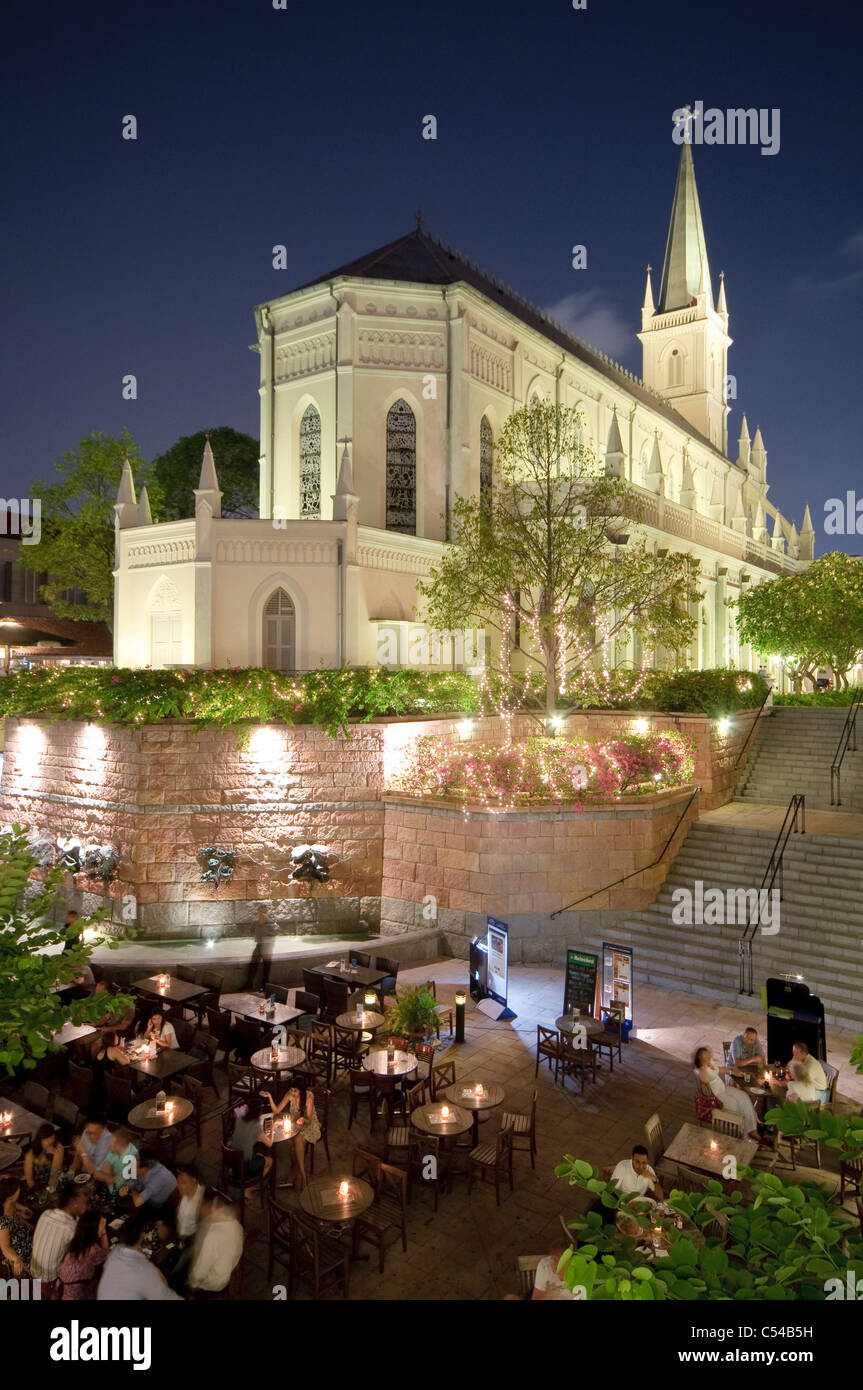 Restaurants and bars at Fountain Court at night with church of former