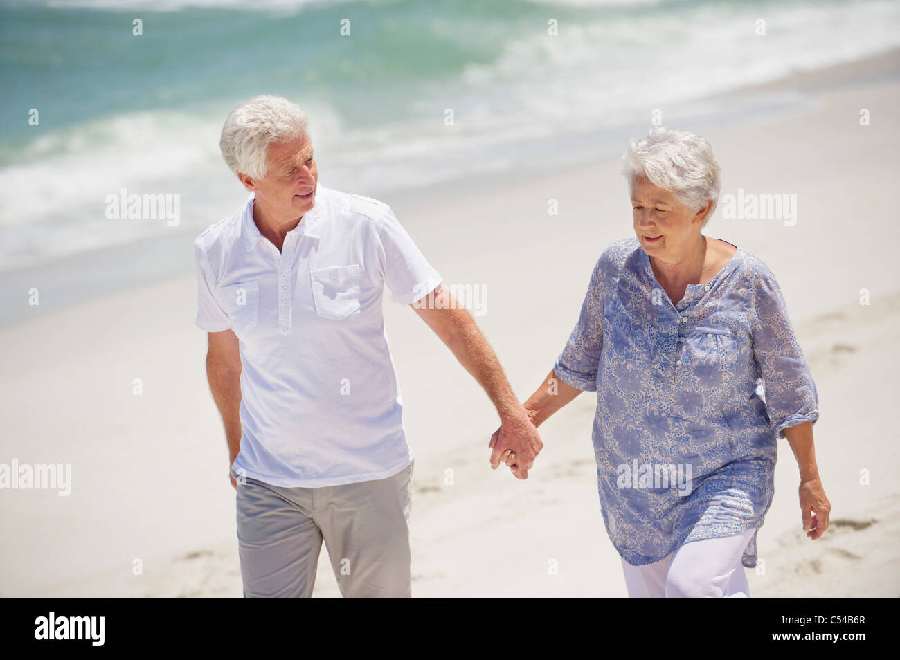 Senior couple walking on the beach Stock Photo - Alamy