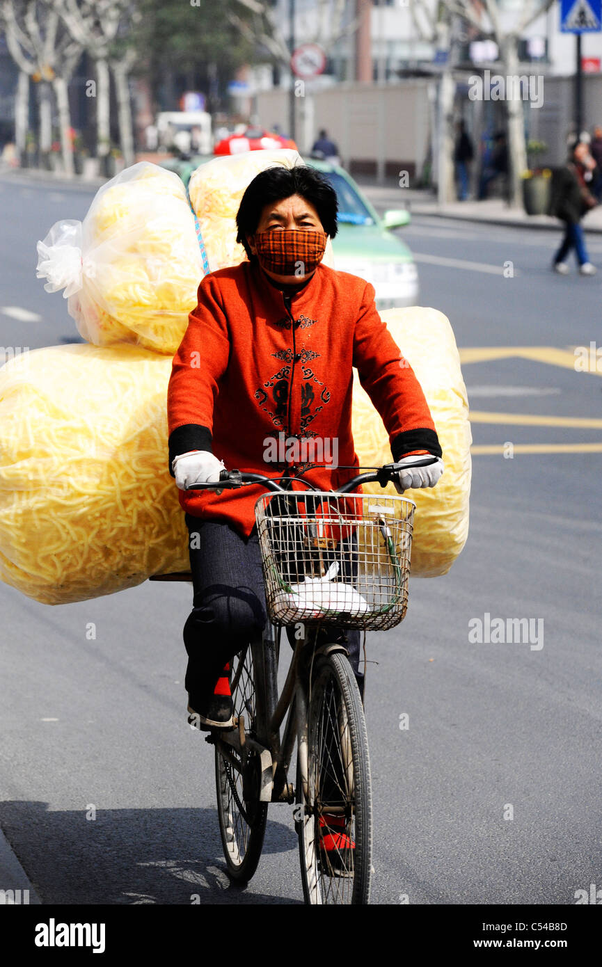 A cyclist carrying goods in Shanghai Stock Photo