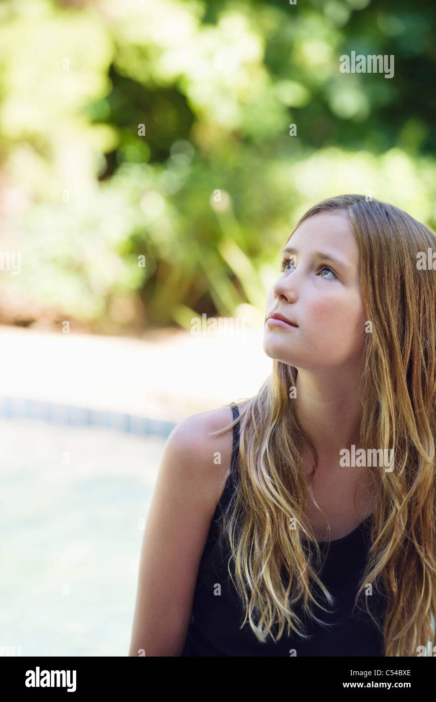 Little girl sitting by the swimming pool and thinking Stock Photo Alamy