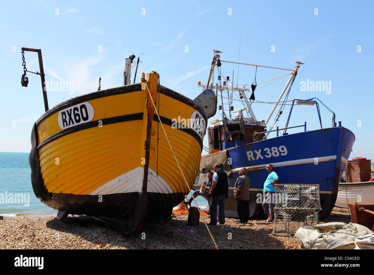 Traditional fishing boats on Hastings beach unloading catch of