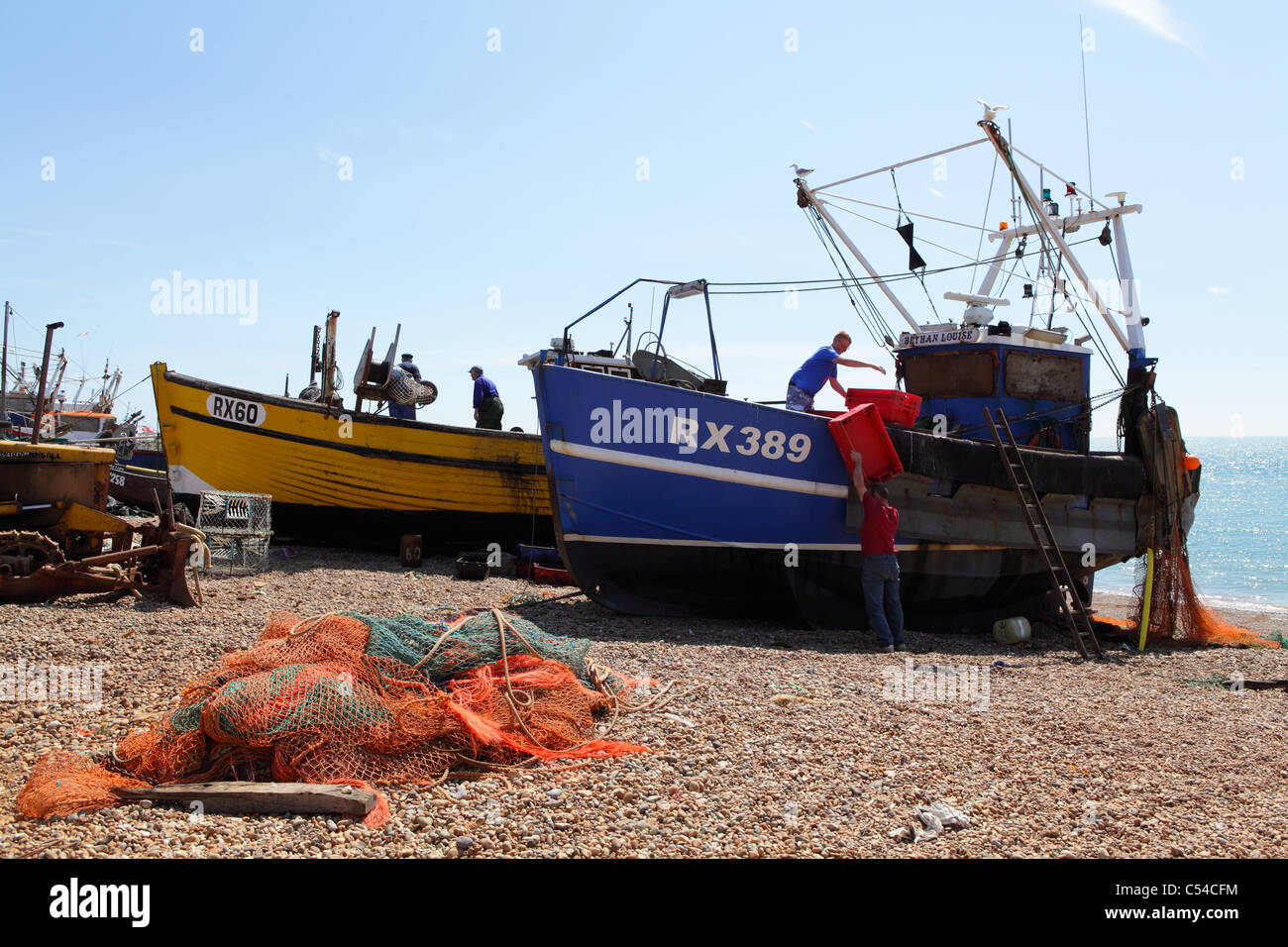 Traditional fishing boats unloading catch of fish on Hastings beach East Sussex England UK GB Stock Photo