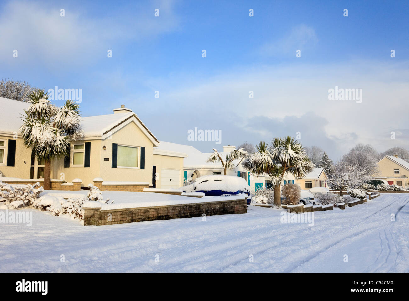 Snow scene on a suburban residential street and houses after heavy winter snowfall in December 2010 on Isle of Anglesey Wales UK Britain Stock Photo