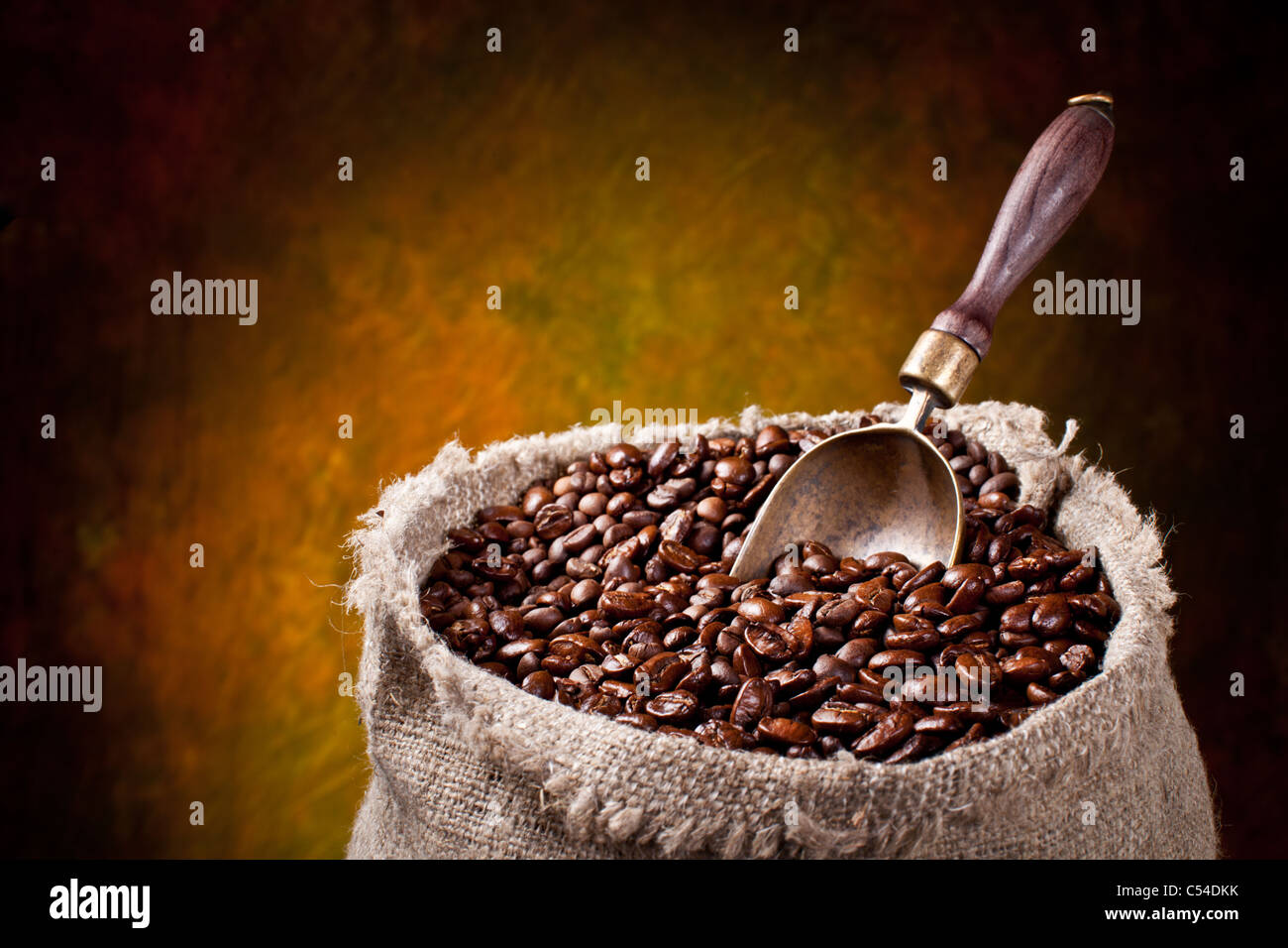 Sack of coffee beans and scoop. On a dark background. Stock Photo