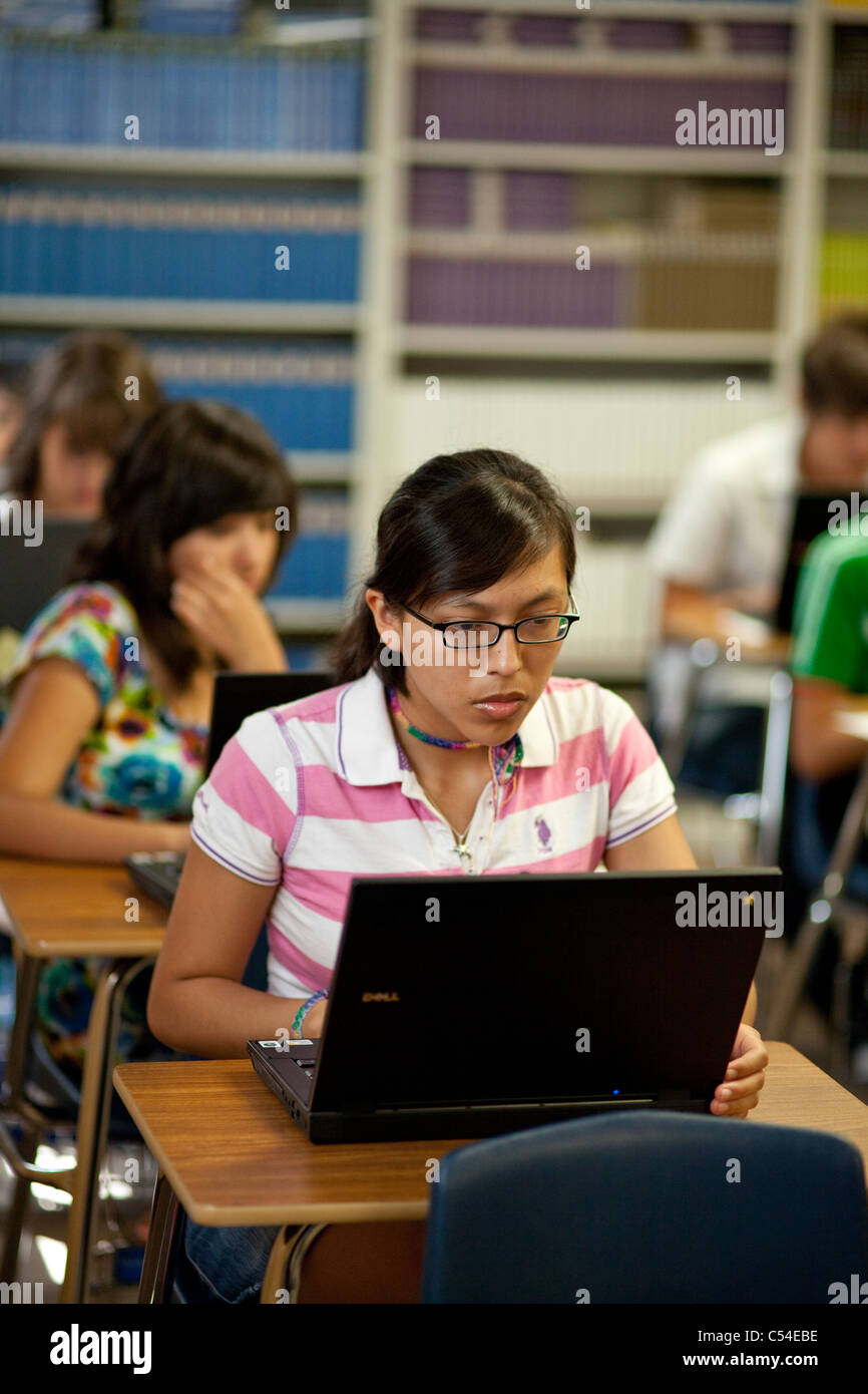 Female Hispanic teen uses laptop computer for school work in El Paso, Texas high school