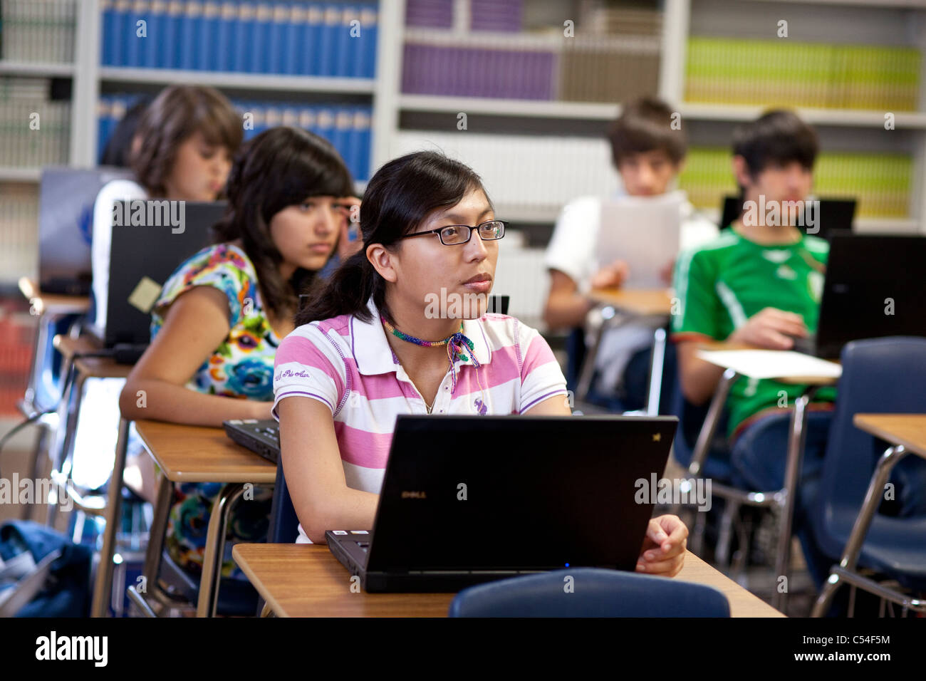 High school students with individual laptop computers pay attention