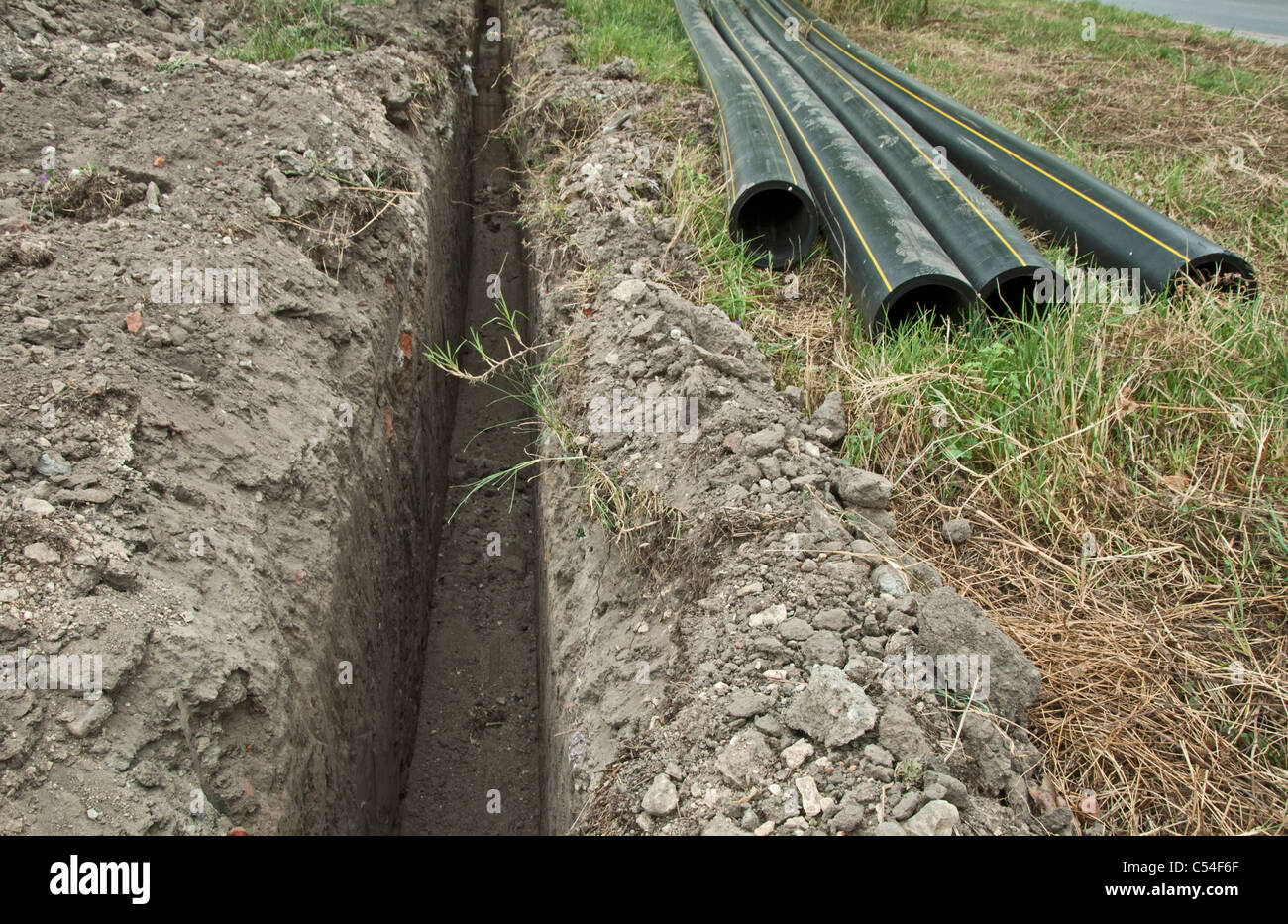 Black deep plastic pipes and ditch Stock Photo Alamy