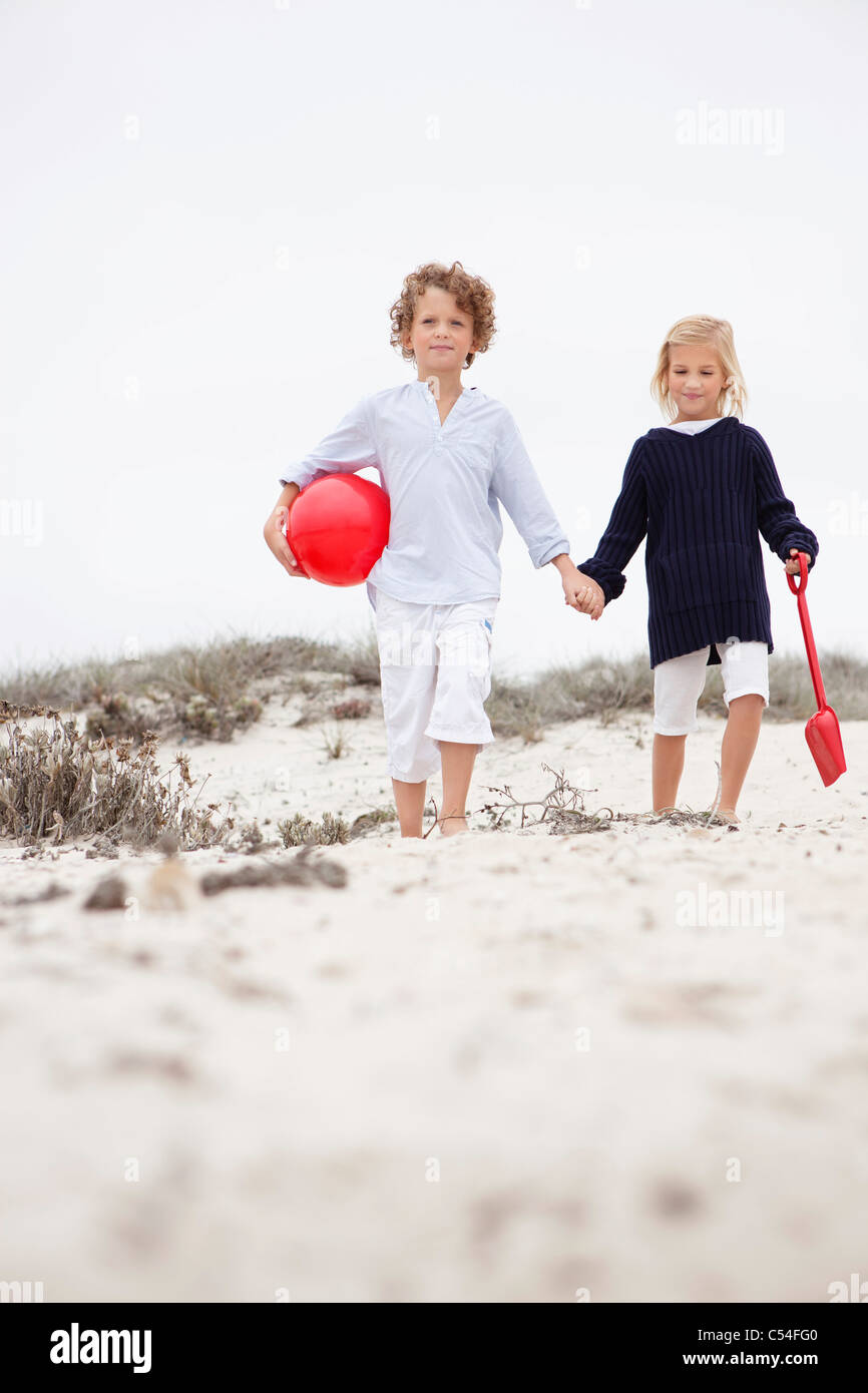 Siblings holding hands and walking Stock Photo - Alamy