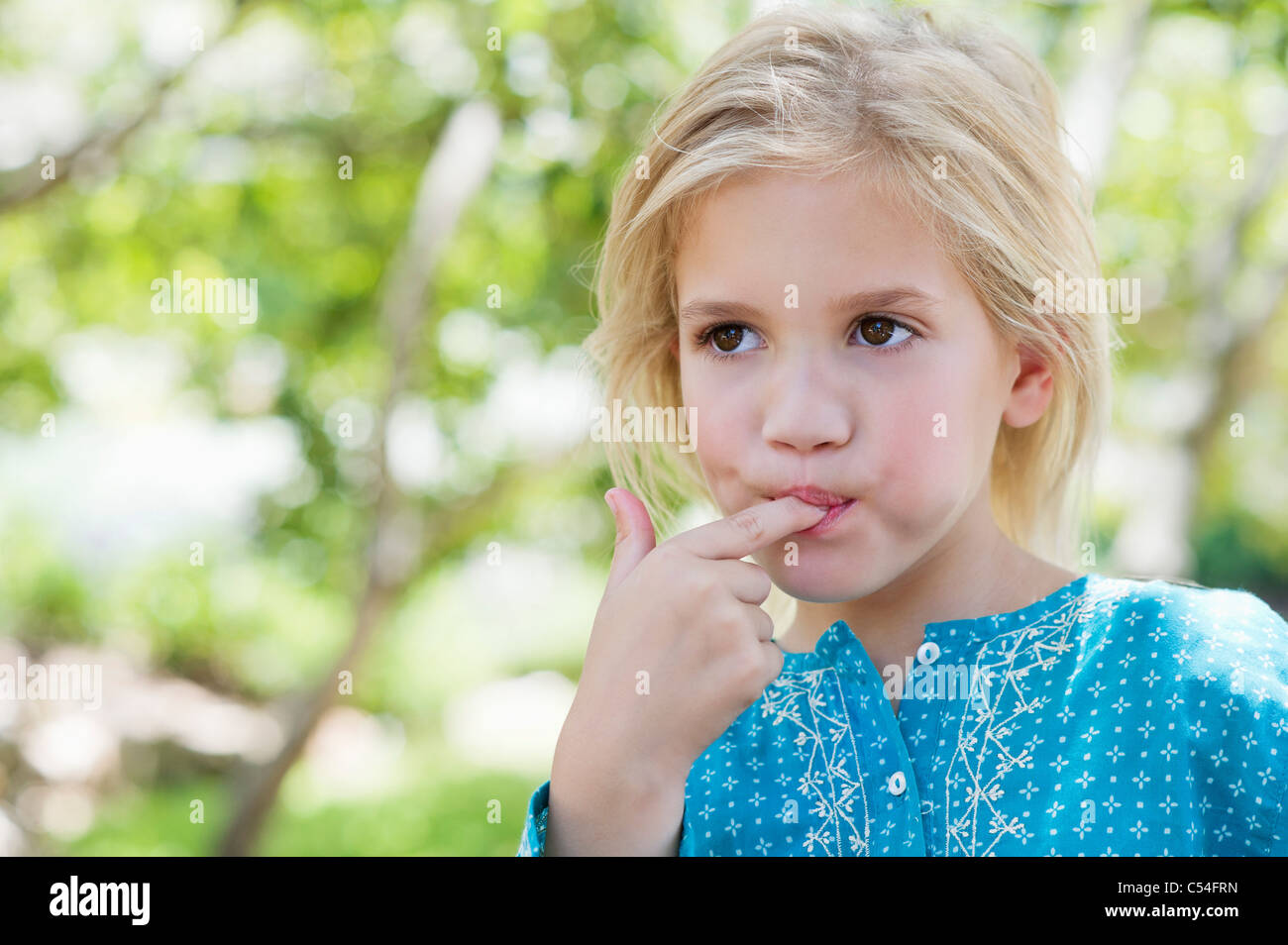 Close up of a girl with finger in her mouth hi-res stock photography ...