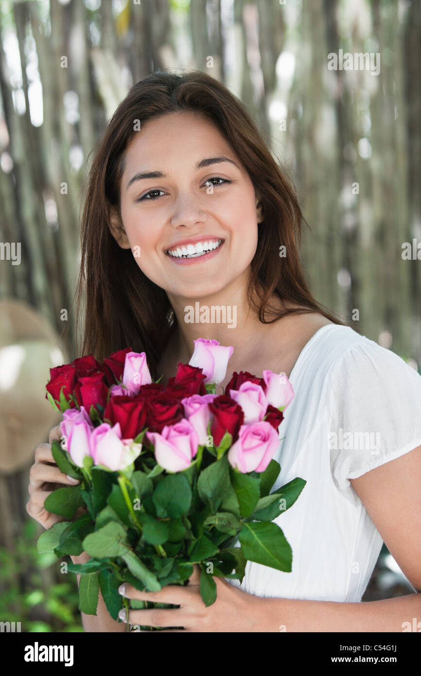 Portrait of a young woman holding bunch of colorful roses Stock Photo ...