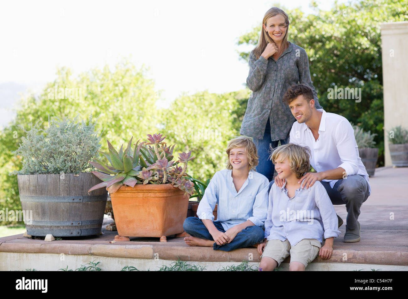 Portrait of a woman standing with her family outside house Stock Photo ...