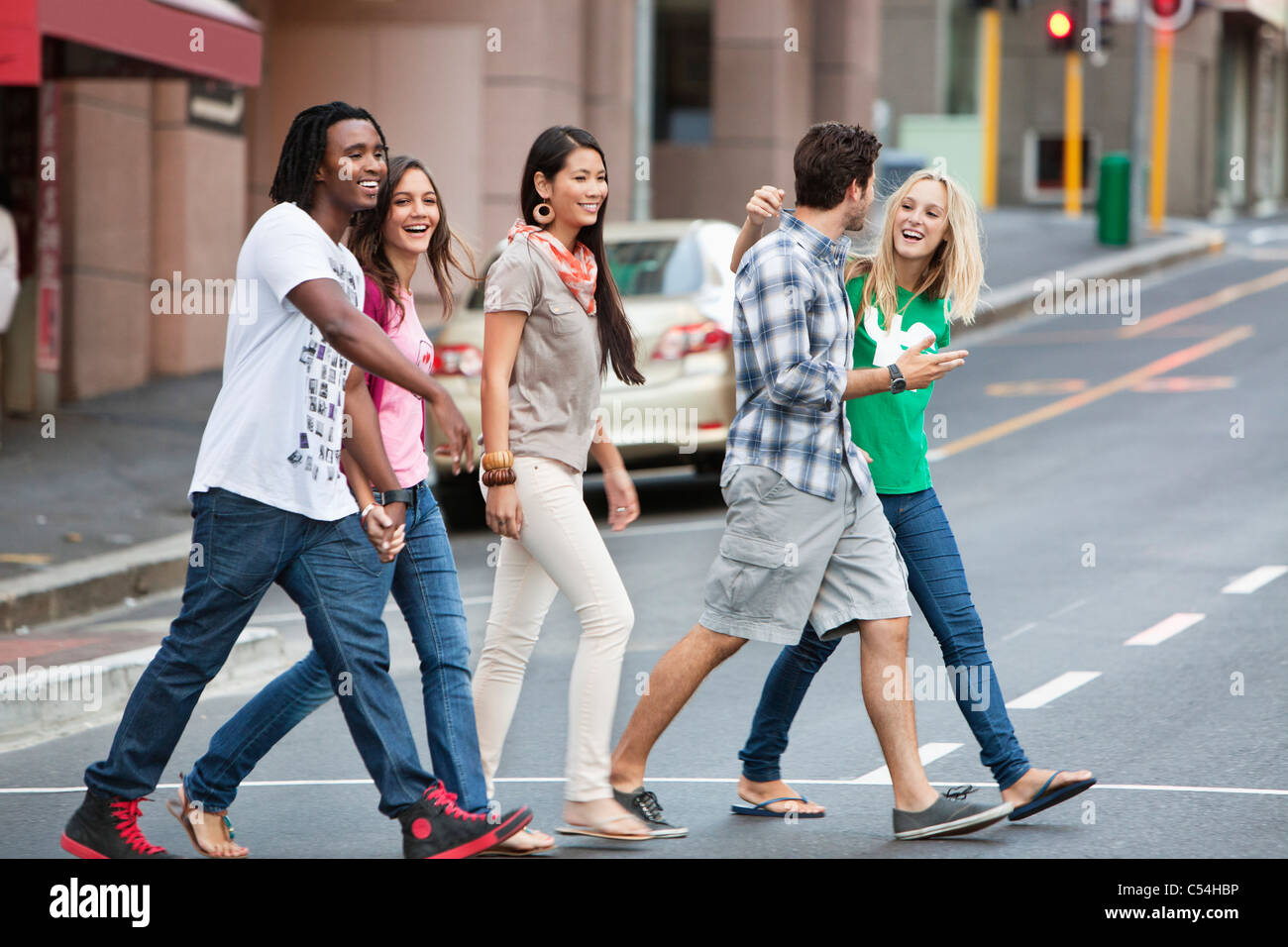 Smiling friends crossing the road Stock Photo Alamy