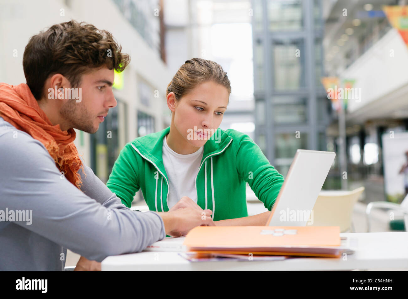 University students using laptop in lobby Stock Photo