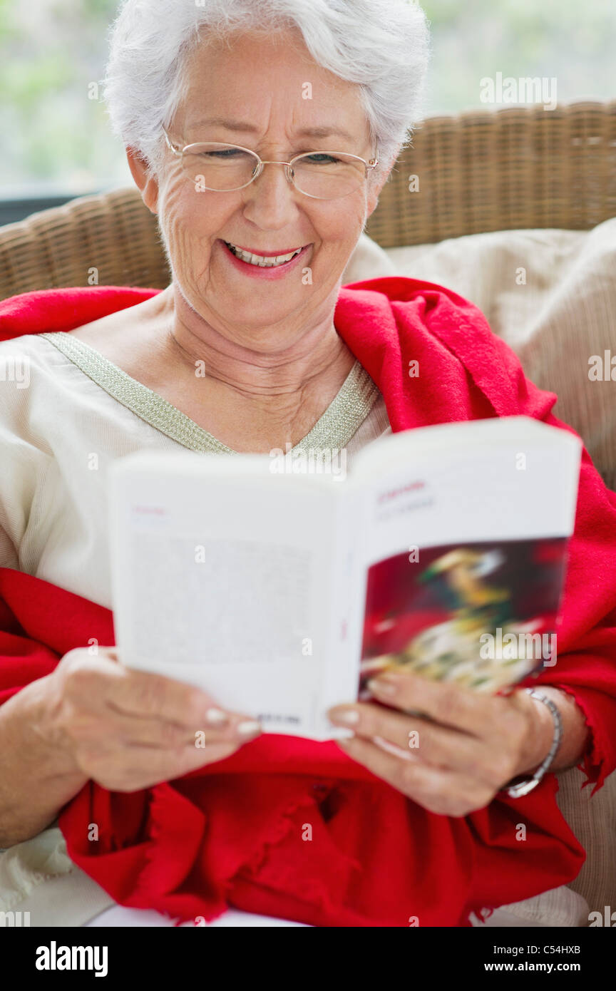 Senior woman reading a magazine and smiling Stock Photo