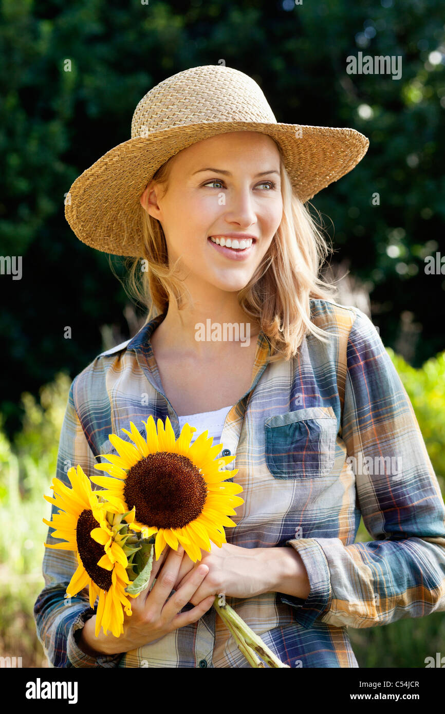 Happy young woman holding sunflowers in a field Stock Photo - Alamy