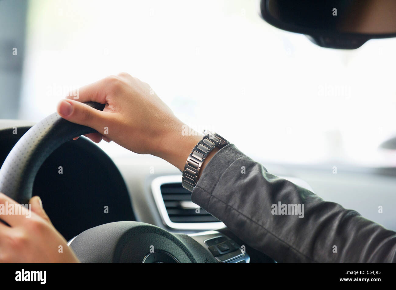 Close-up of a human hand on car steering wheel Stock Photo