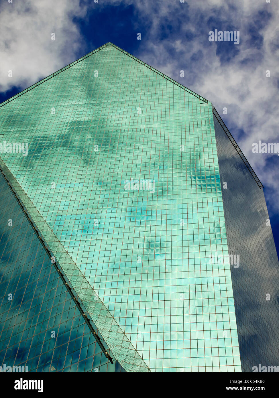 Detail of modern skyscraper with all-glass facades shot against a deep blue sky with clouds. Stock Photo