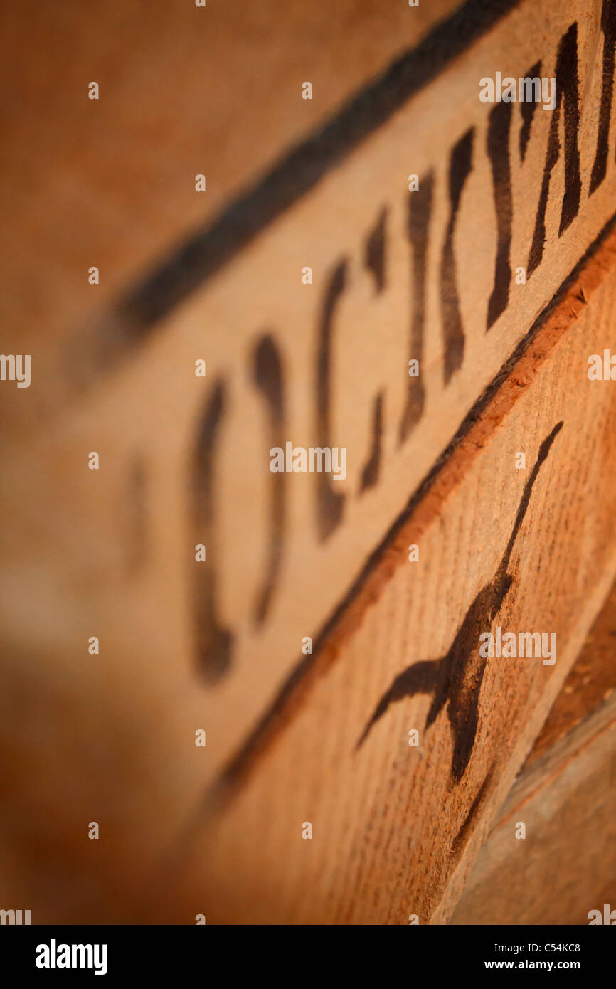 The word stockyard and the silhouette of a longhorn skull painted with a stencil on a wooden crate. Stock Photo