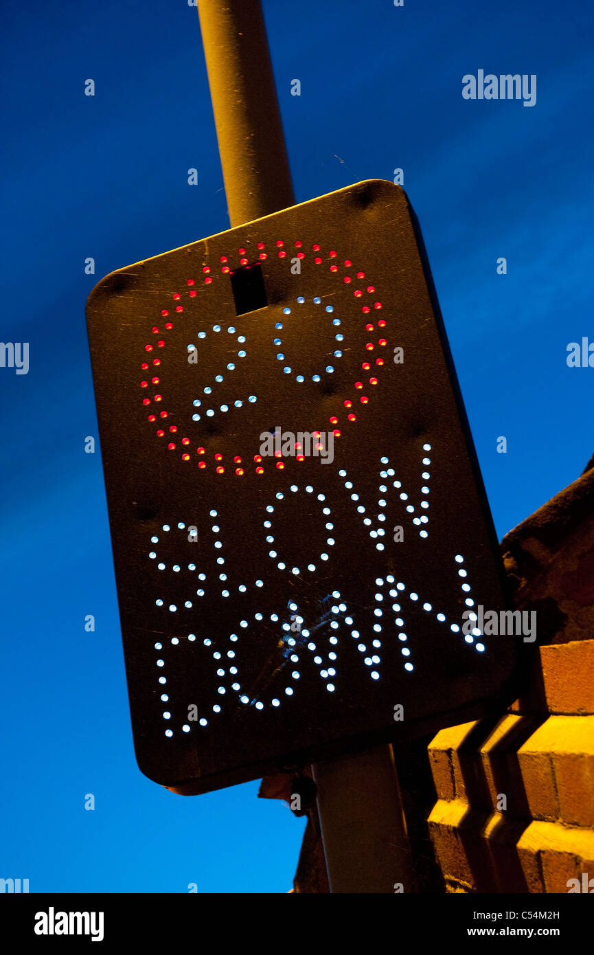 Illuminated road safety sign showing speed limit of 20 miles per hour on a road in England. Stock Photo