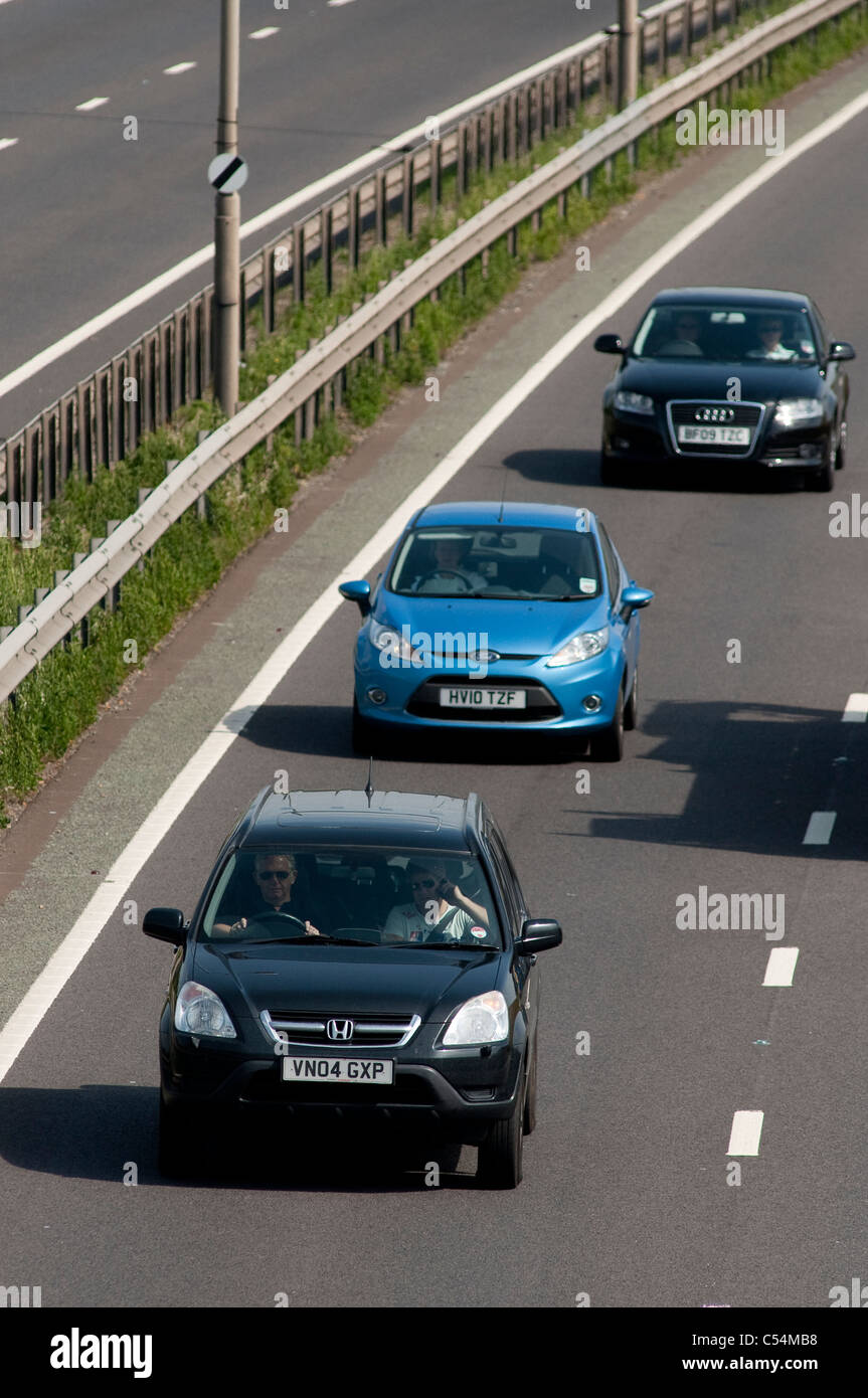 Cars travelling at speed too close to each other in the outside lane of a dual carriageway in England. Stock Photo