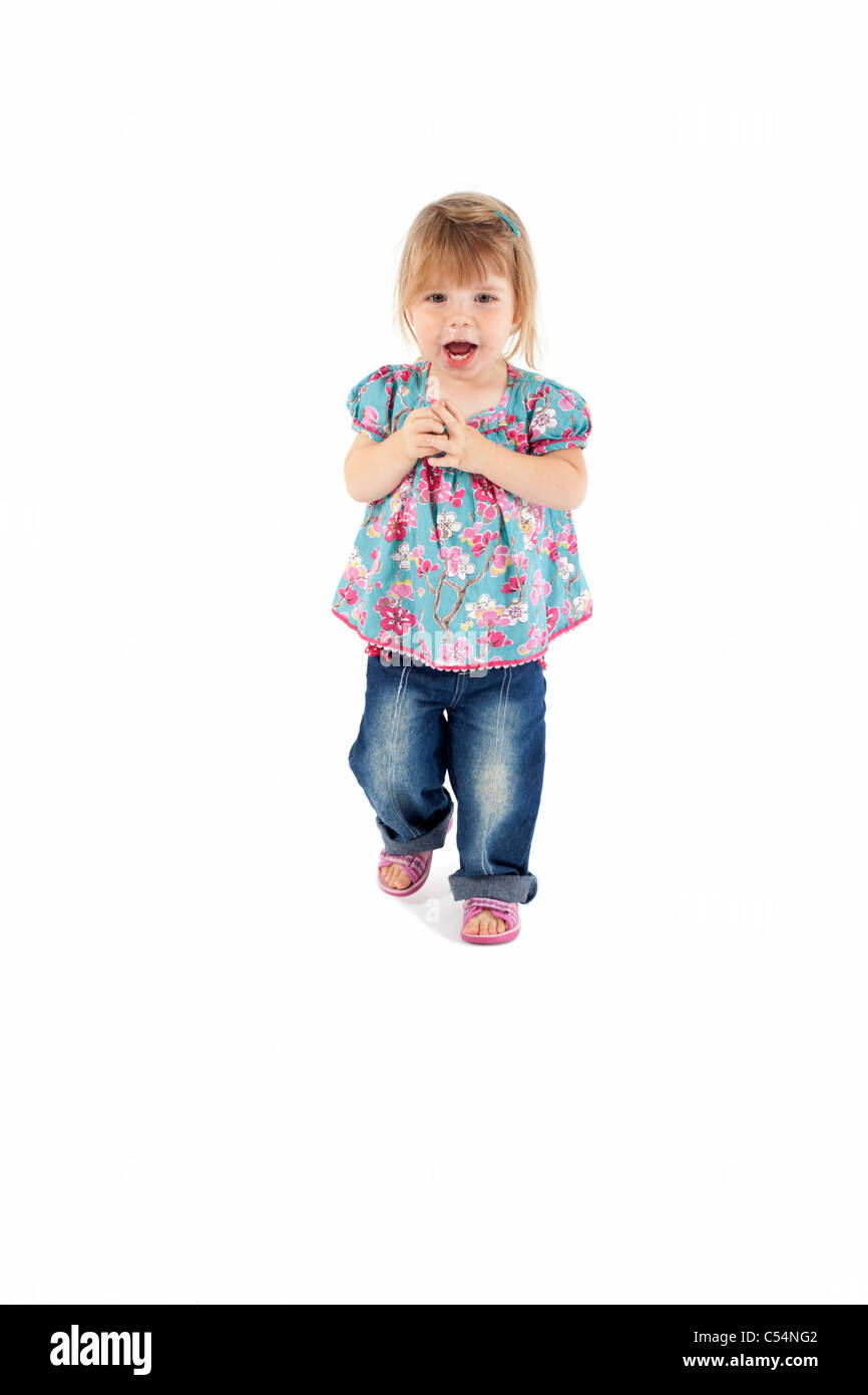 female toddler walking towards camera on isolated white background Stock Photo