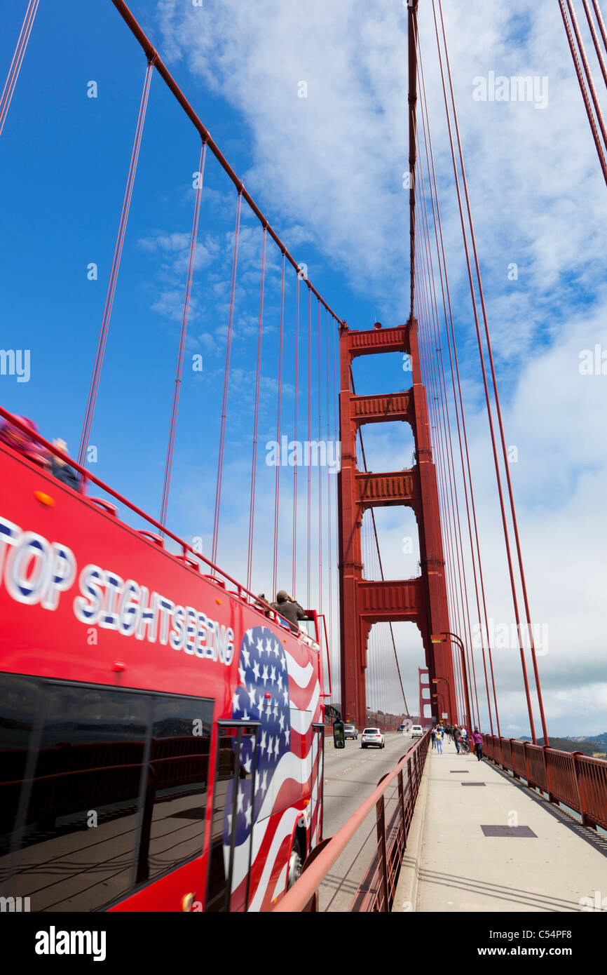 Red tour bus crossing the Golden Gate Bridge linking the city with Marin County City of San Francisco California USA Stock Photo