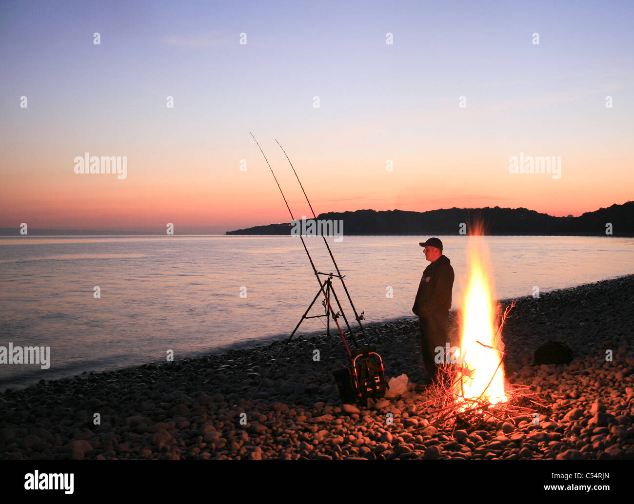 night fishing on a pebble on the cold Knapp beach south wales with a fire  to keep warm Stock Photo - Alamy