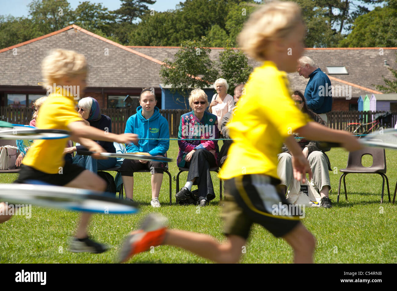 Parents watching their children compete at the annual School sports day at a small primary school, UK Stock Photo