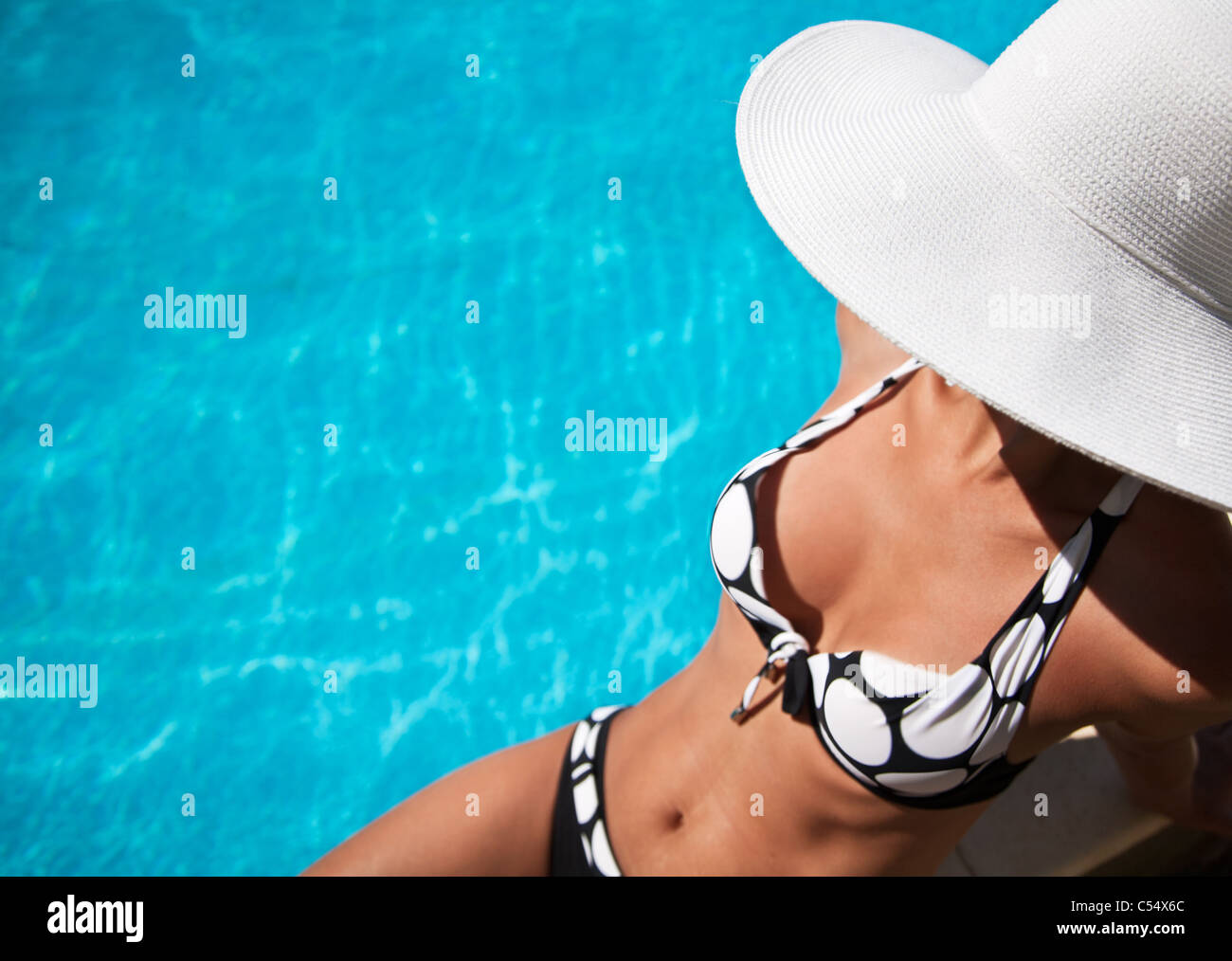 Young Woman Sitting On The Ledge Of The Pool Stock Photo Alamy