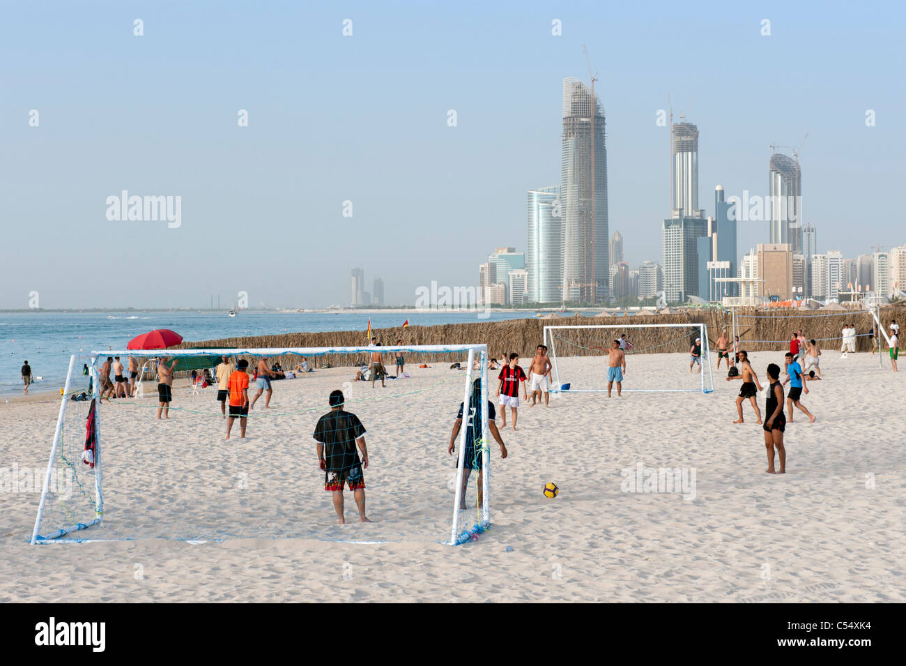 People playing football on beach in Abu Dhabi United Arab Emirates UAE Stock Photo