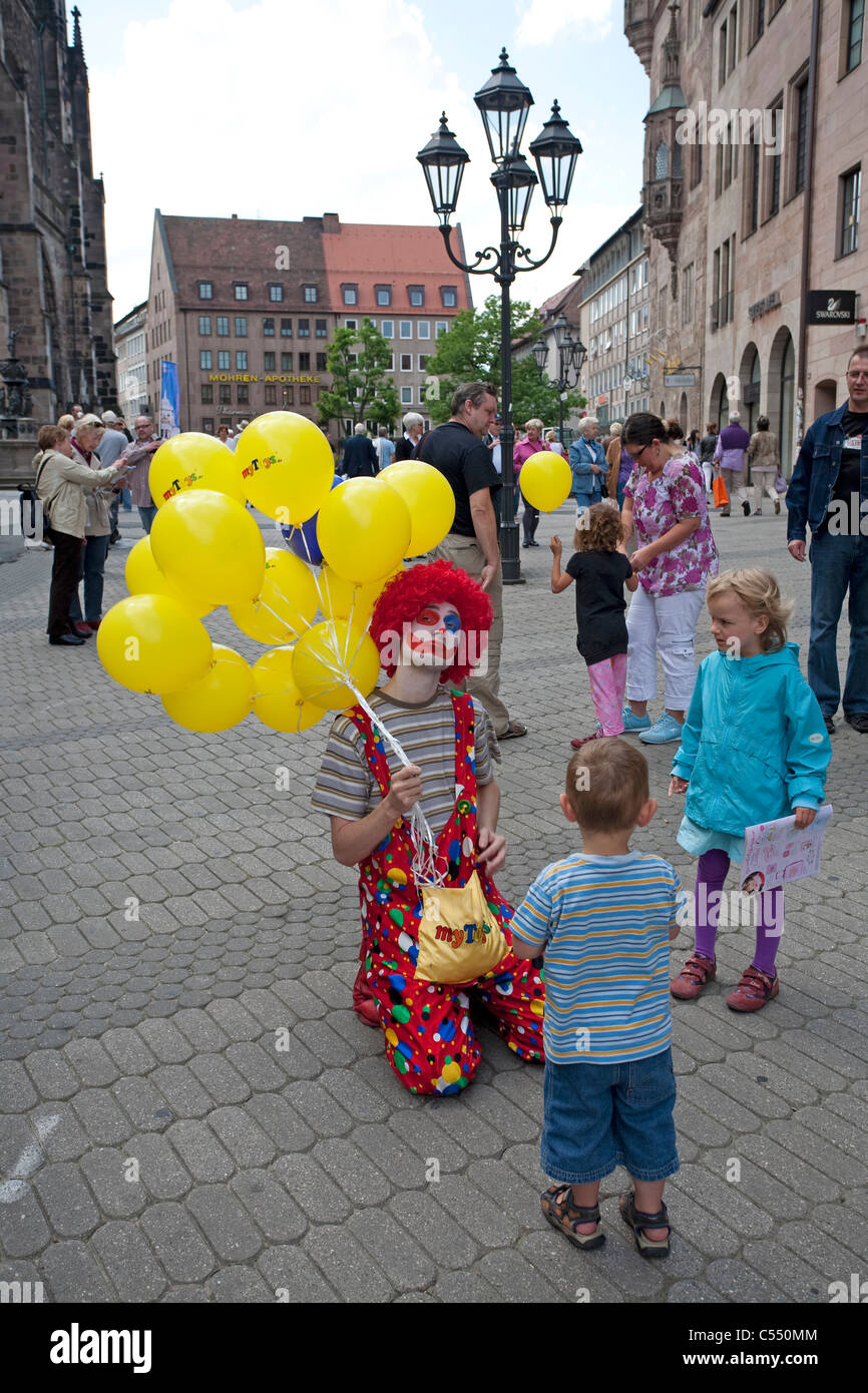Clown mit Luftballons Kinder an der Lorenzkirche in der Altstadt Clown with childrens at the St. Lorenz church old town Stock Photo