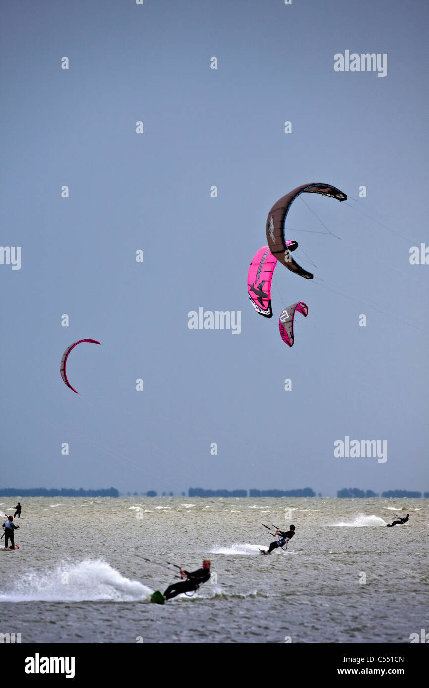 The Netherlands, near Bakhuizen, Wind surfers and kite surfers on lake called IJsselmeer. Stock Photo