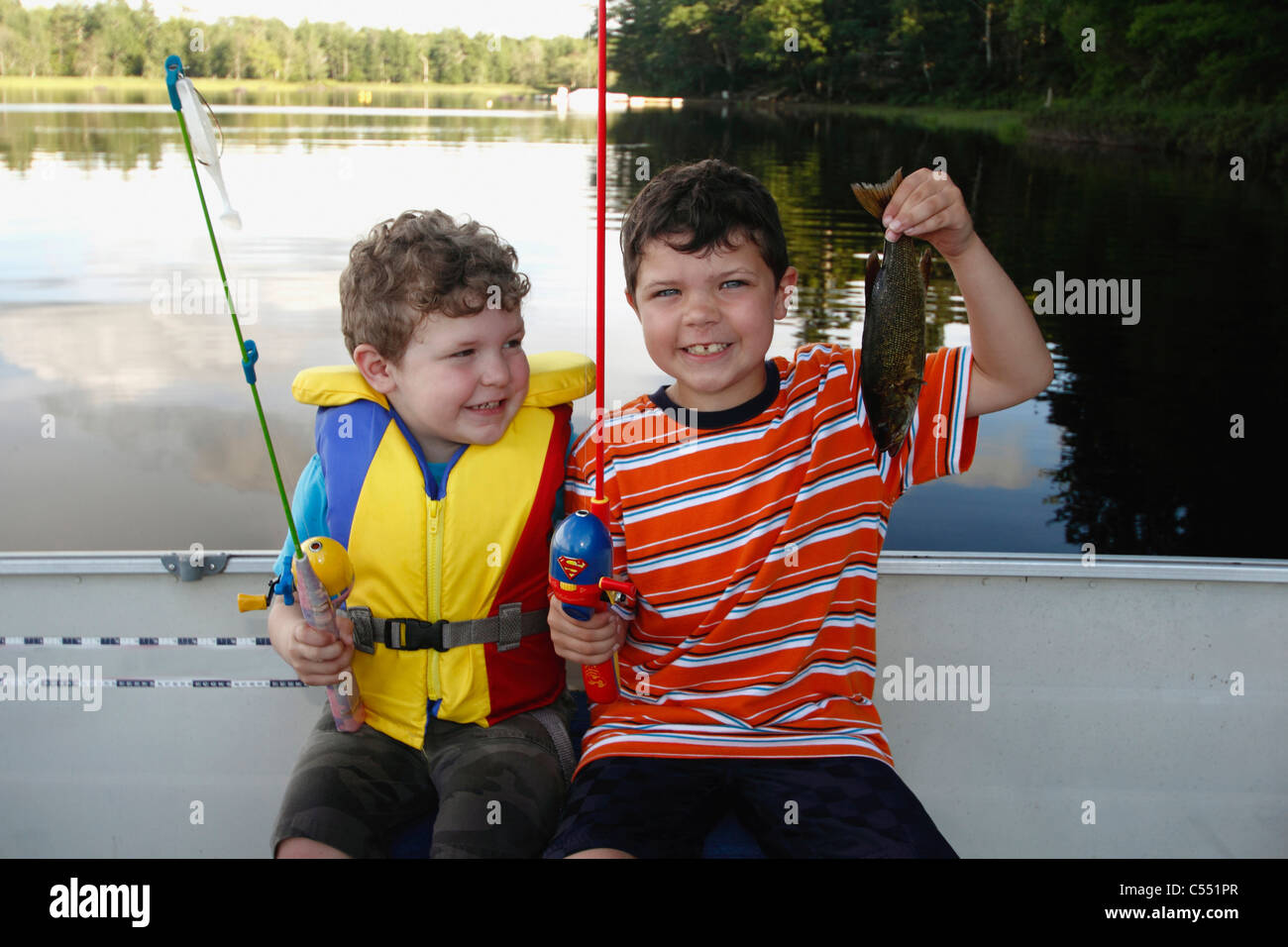 Boy bass fishing in a lake with his brother Stock Photo Alamy
