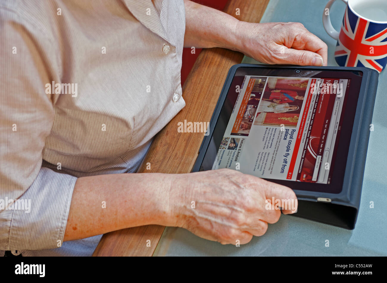Woman using an Apple iPad tablet computer to view the BBC news website Stock Photo