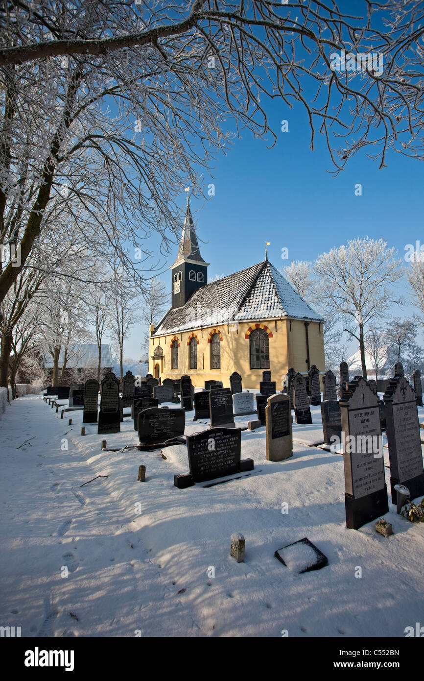 The Netherlands, Ferwoude, Church and graveyard in frost and snow. Stock Photo