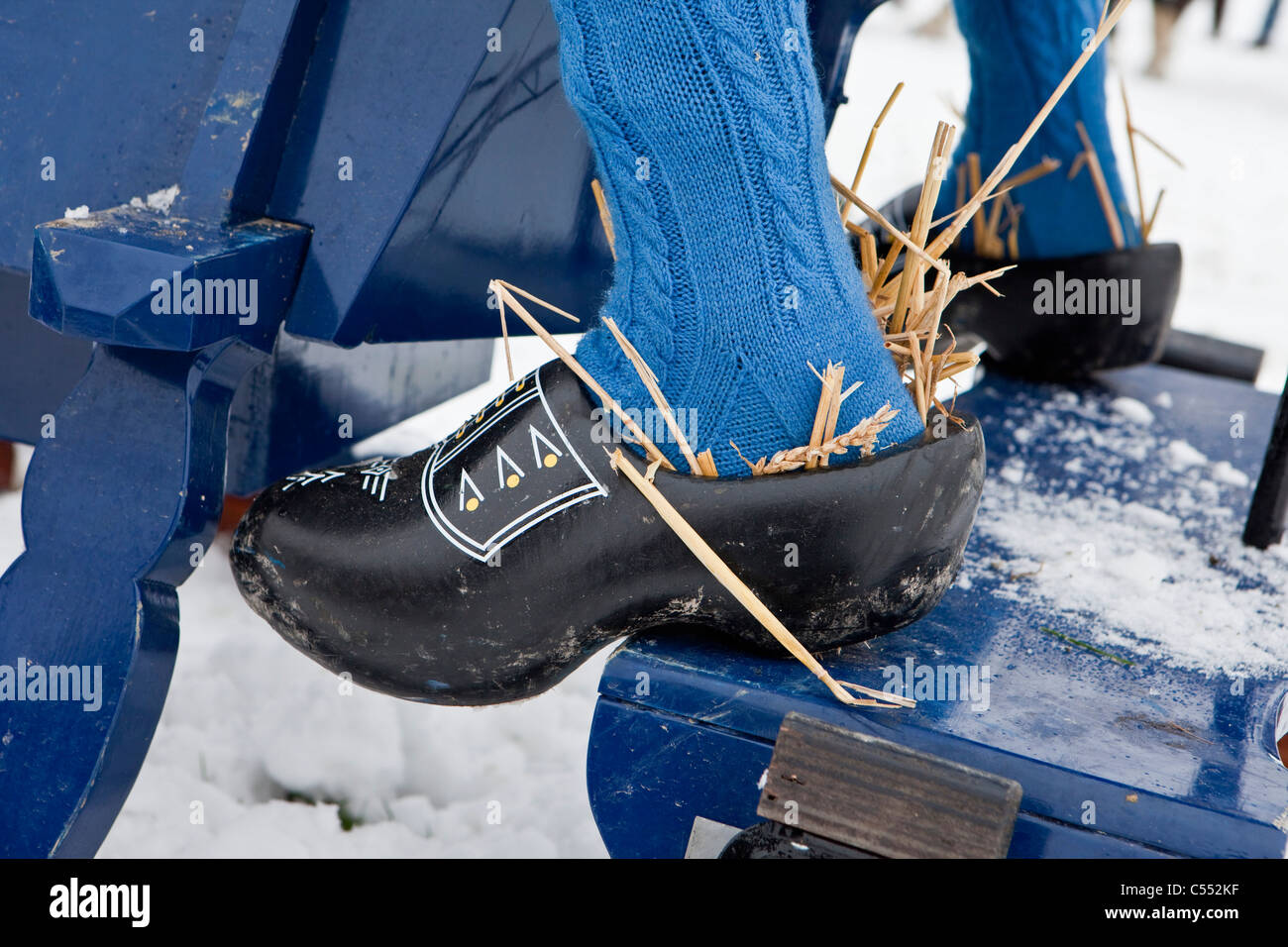 Holland, Oudemirdum, Close up wooden shoes or clogs belonging to rider of antique horse sledge. The straw keeps the feet warm Stock Photo