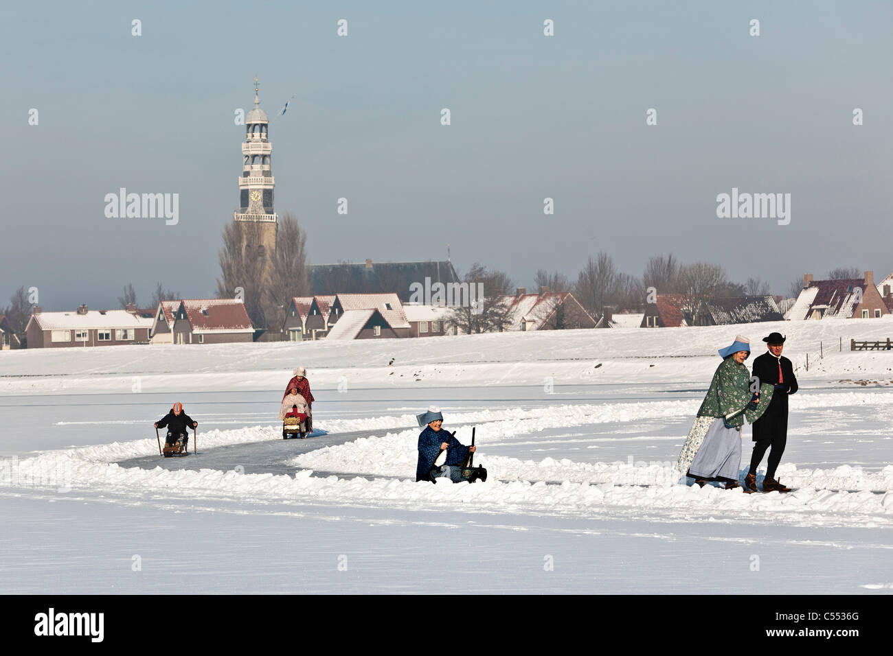 Dutch capital of skating culture. People in traditional dress, figure scating, sledging with prickers, and skating with sledge. Stock Photo
