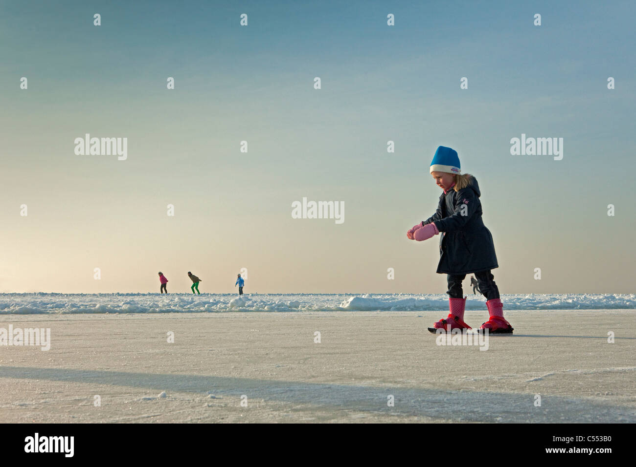 The Netherlands, Hindeloopen, Dutch capital of skating culture. Girl learning to skate on lake called IJsselmeer. Stock Photo