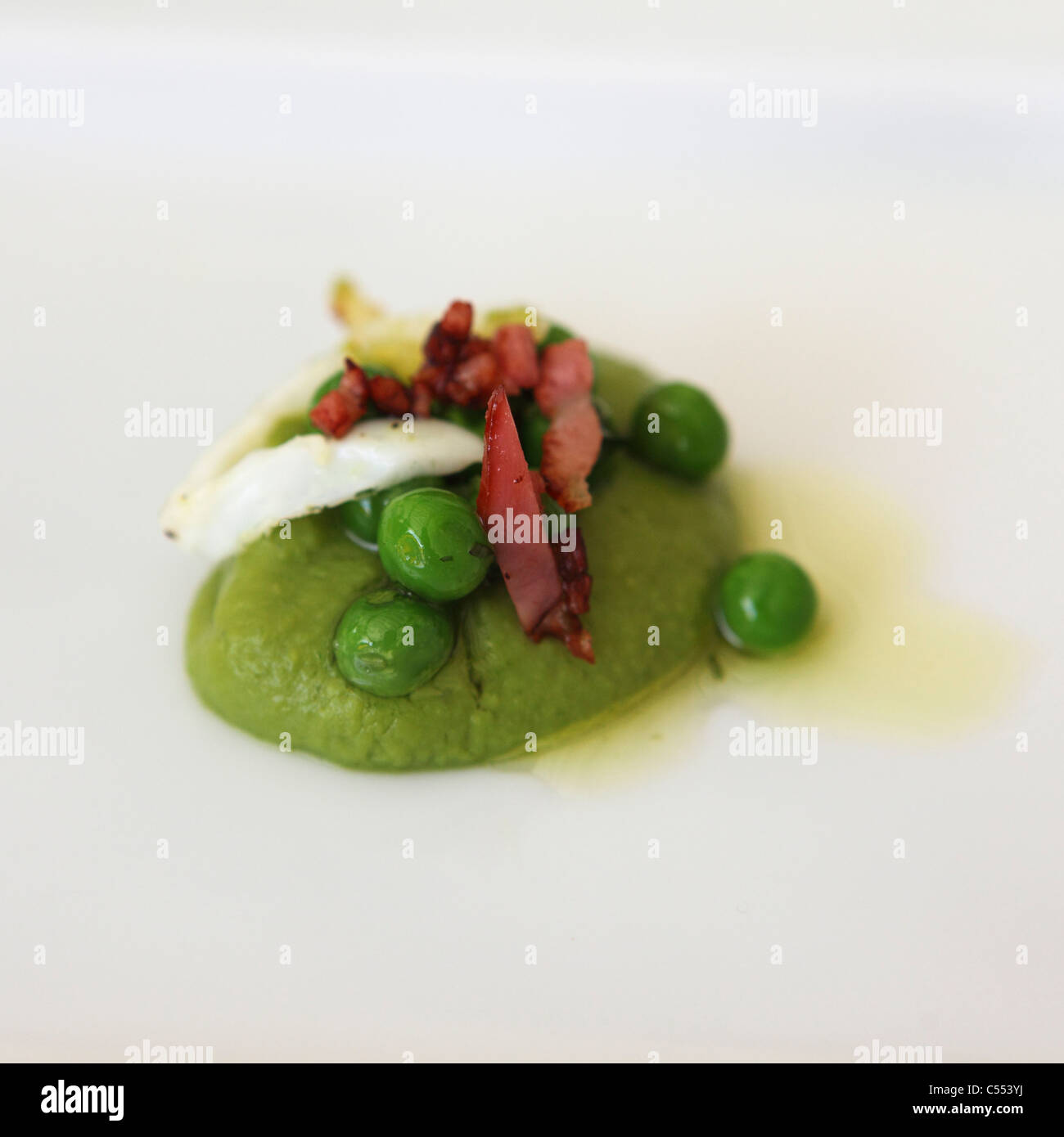 Peas are served with crispy bacon and corncrake egg. Stock Photo