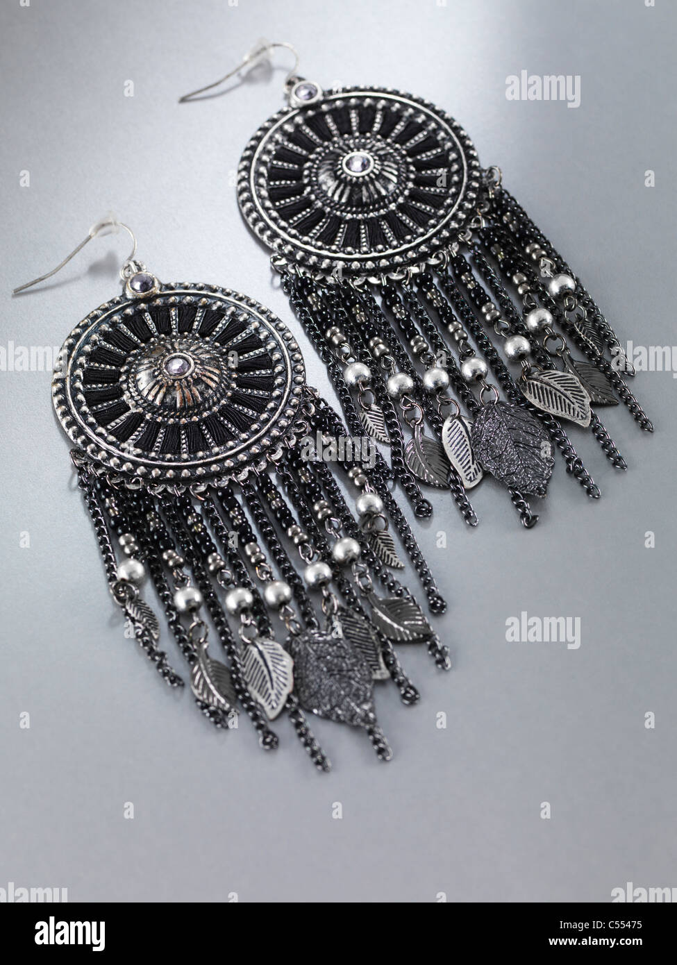 Closeup of a a pair of earrings. Jewellery isolated on gray background. Stock Photo