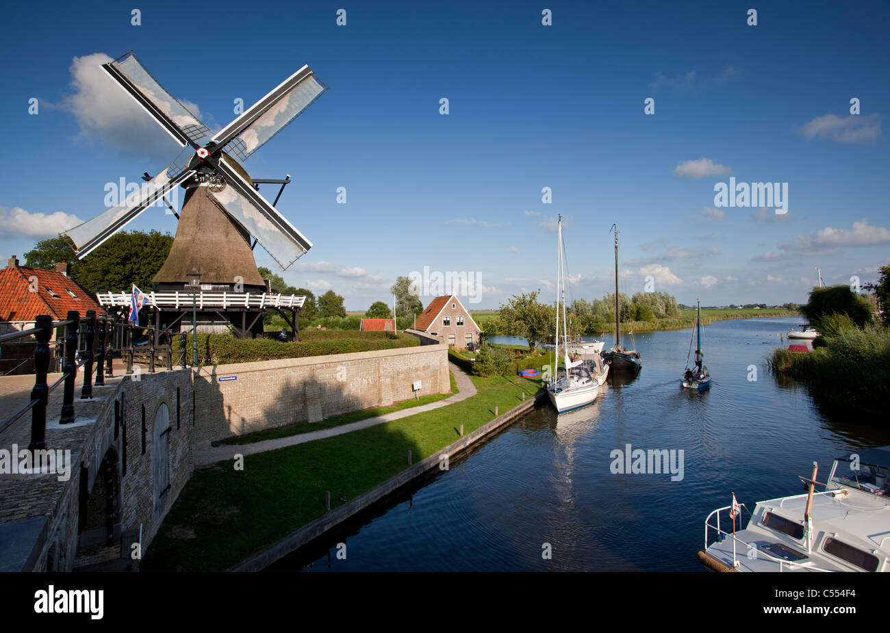The Netherlands, Sloten, Yachts and windmill. Stock Photo